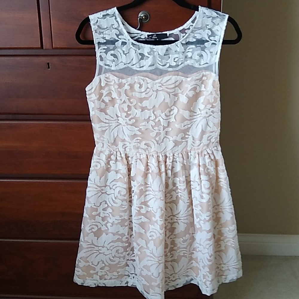 Lace overlay on cream dress. Sheer on top.